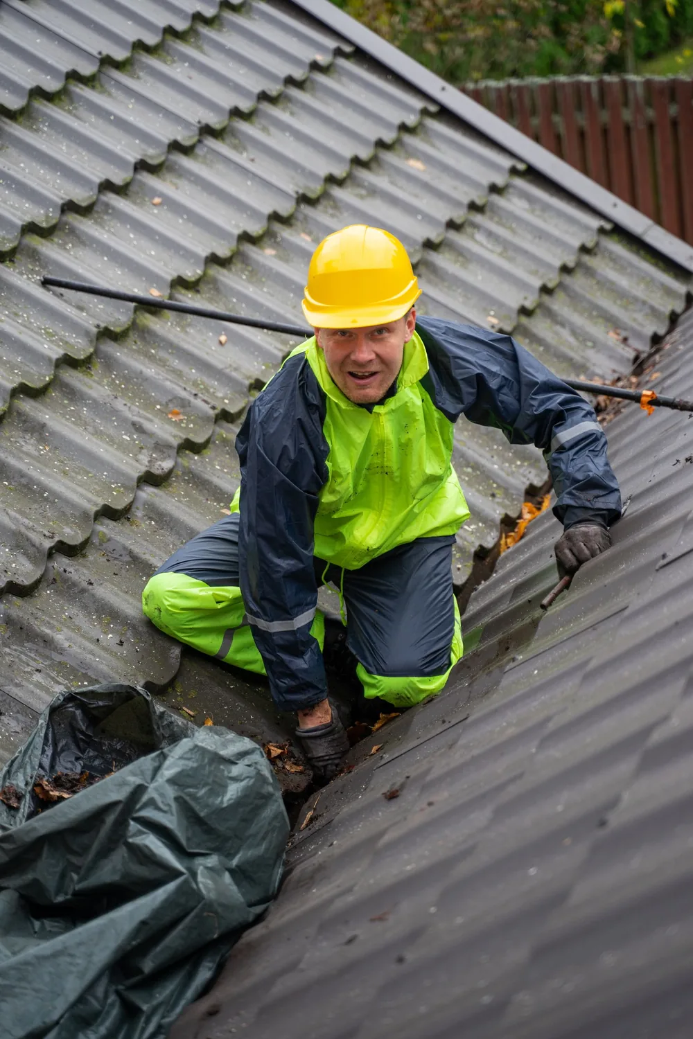 Roofer in hi-vis clothing working on a tiled roof