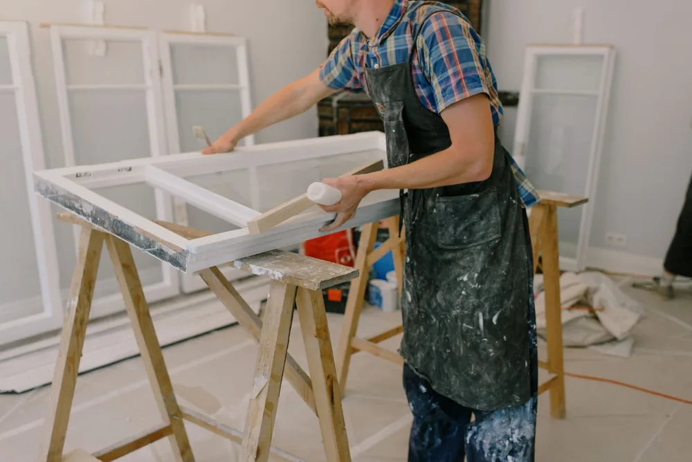 Tradesperson refinishing a window frame
